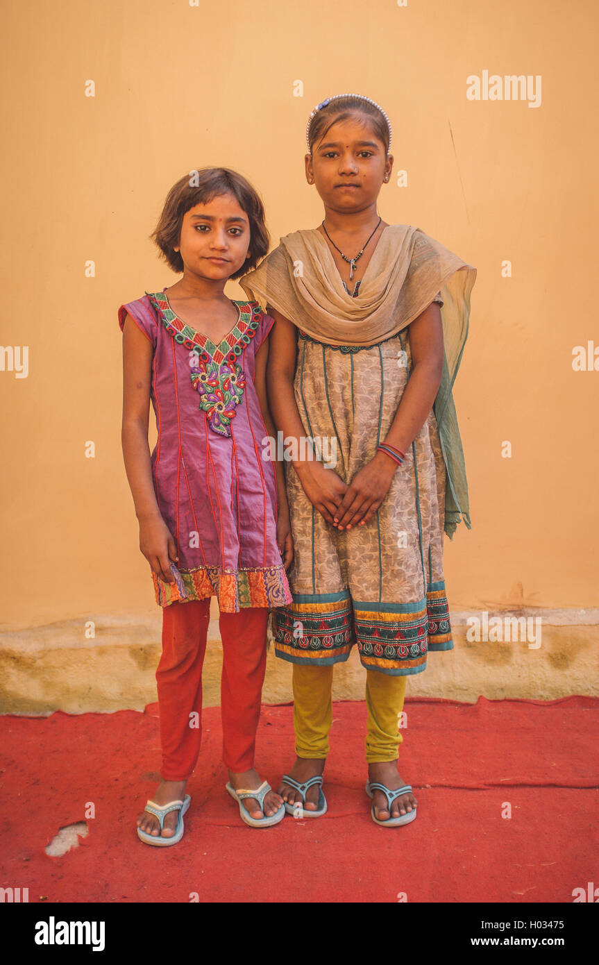 GODWAR REGION, INDIA - 15 FEBRUARY 2015: Two Indian girls pose in front of wall on red carpet. Post-processed with grain, textur Stock Photo