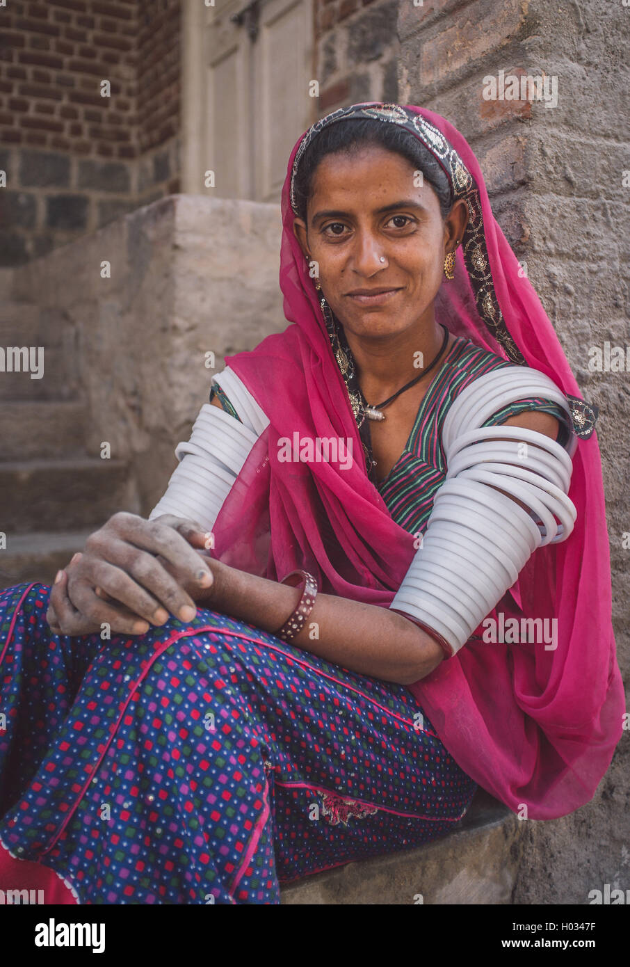 GODWAR REGION, INDIA - 15 FEBRUARY 2015: Indian tribeswoman sitting in front of home in saree decorated with upper-arm bracelets Stock Photo