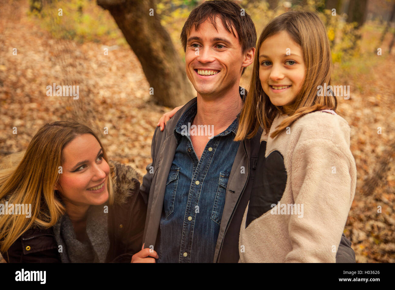 ZAGREB, CROATIA - 15 NOVEMBER 2015: Family of three stand next to each other in park. Stock Photo