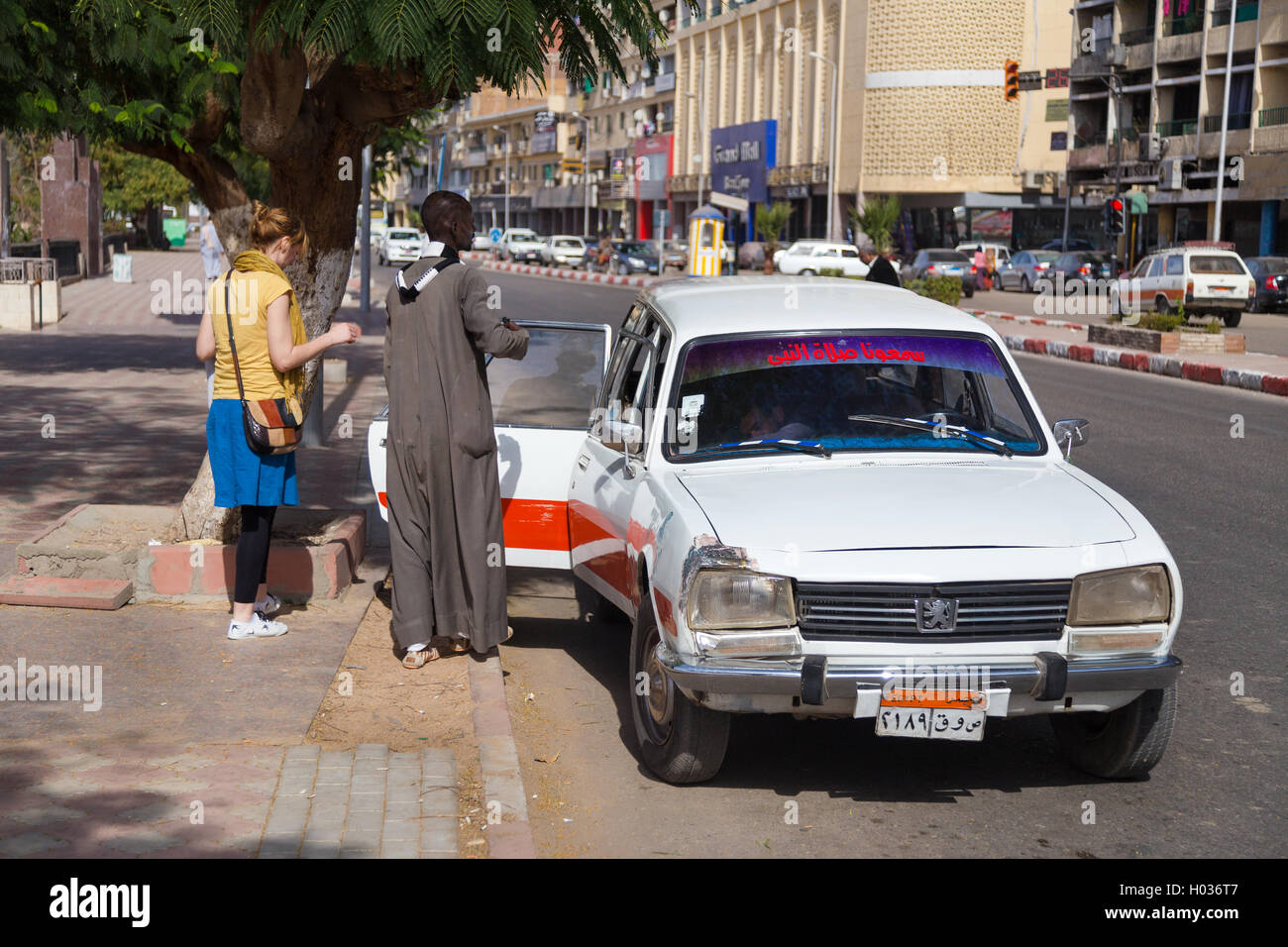 ASWAN, EGYPT - FEBRUARY 5, 2016: People entering old Peugeot 504 taxi at street. Stock Photo