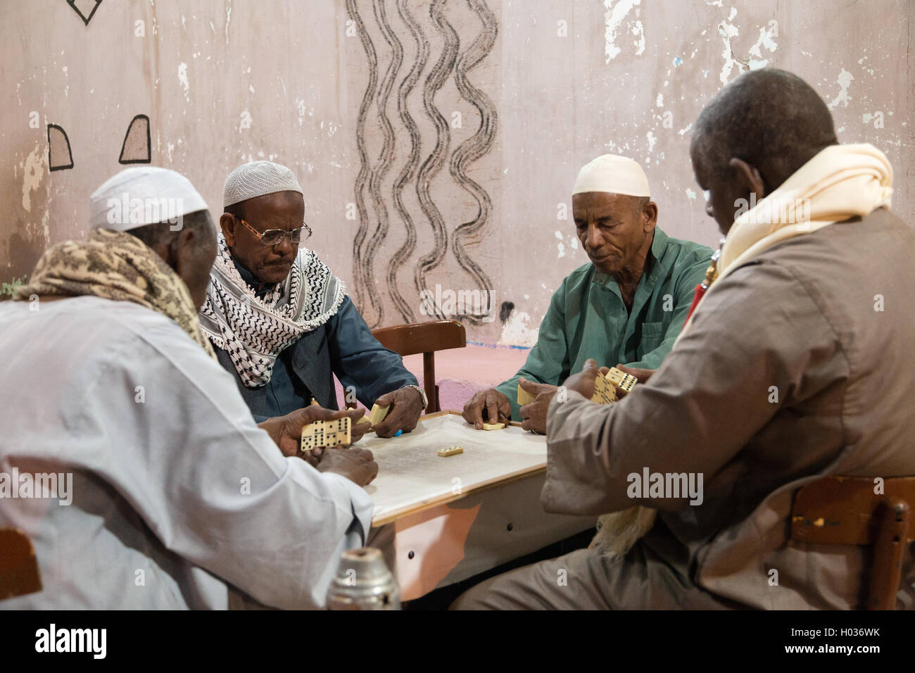 ASWAN, EGYPT - FEBRUARY 5, 2016: Local elderly men playing dominos on Nubian village street. Stock Photo