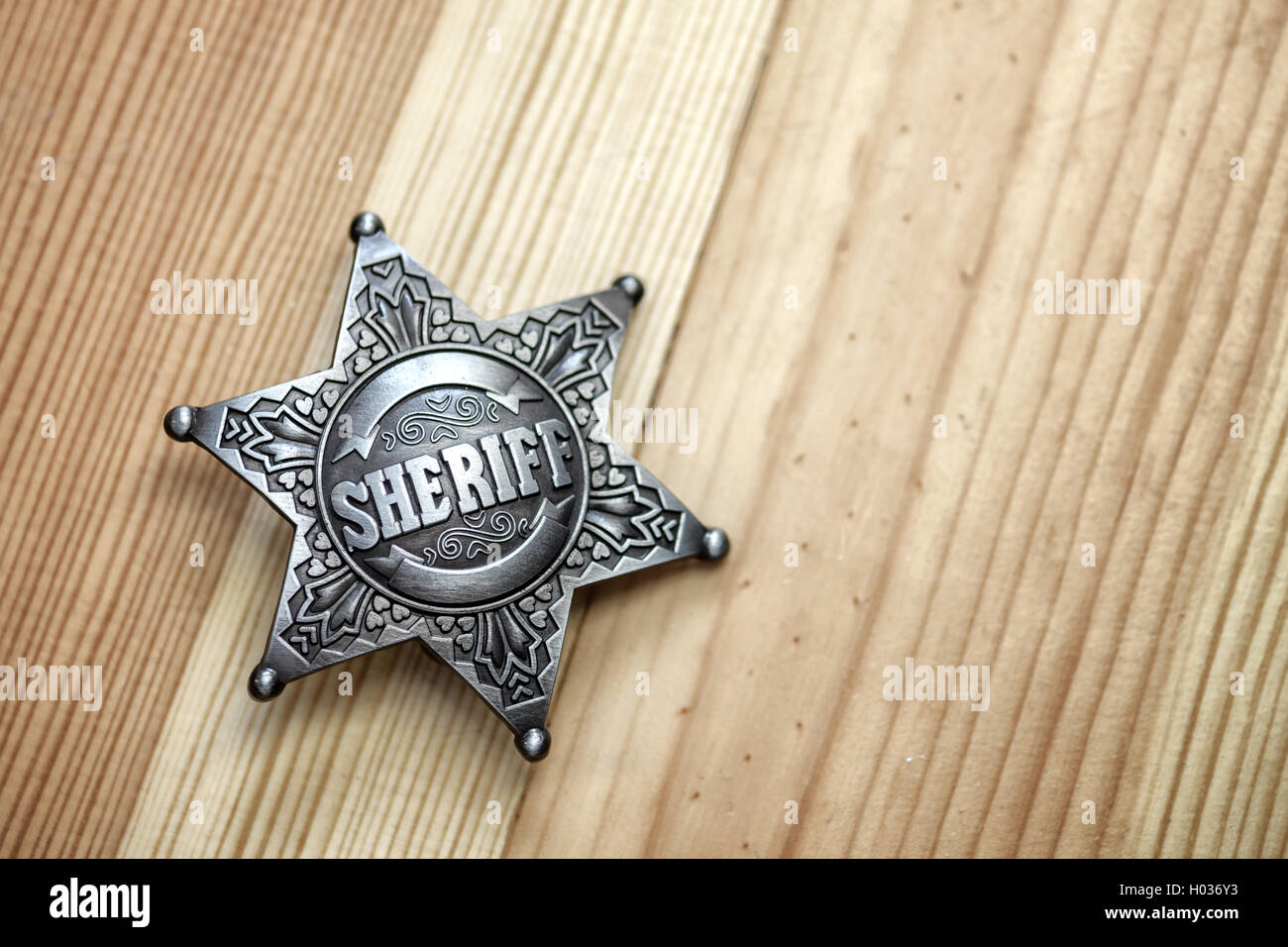 sheriff star on wood table closeup Stock Photo