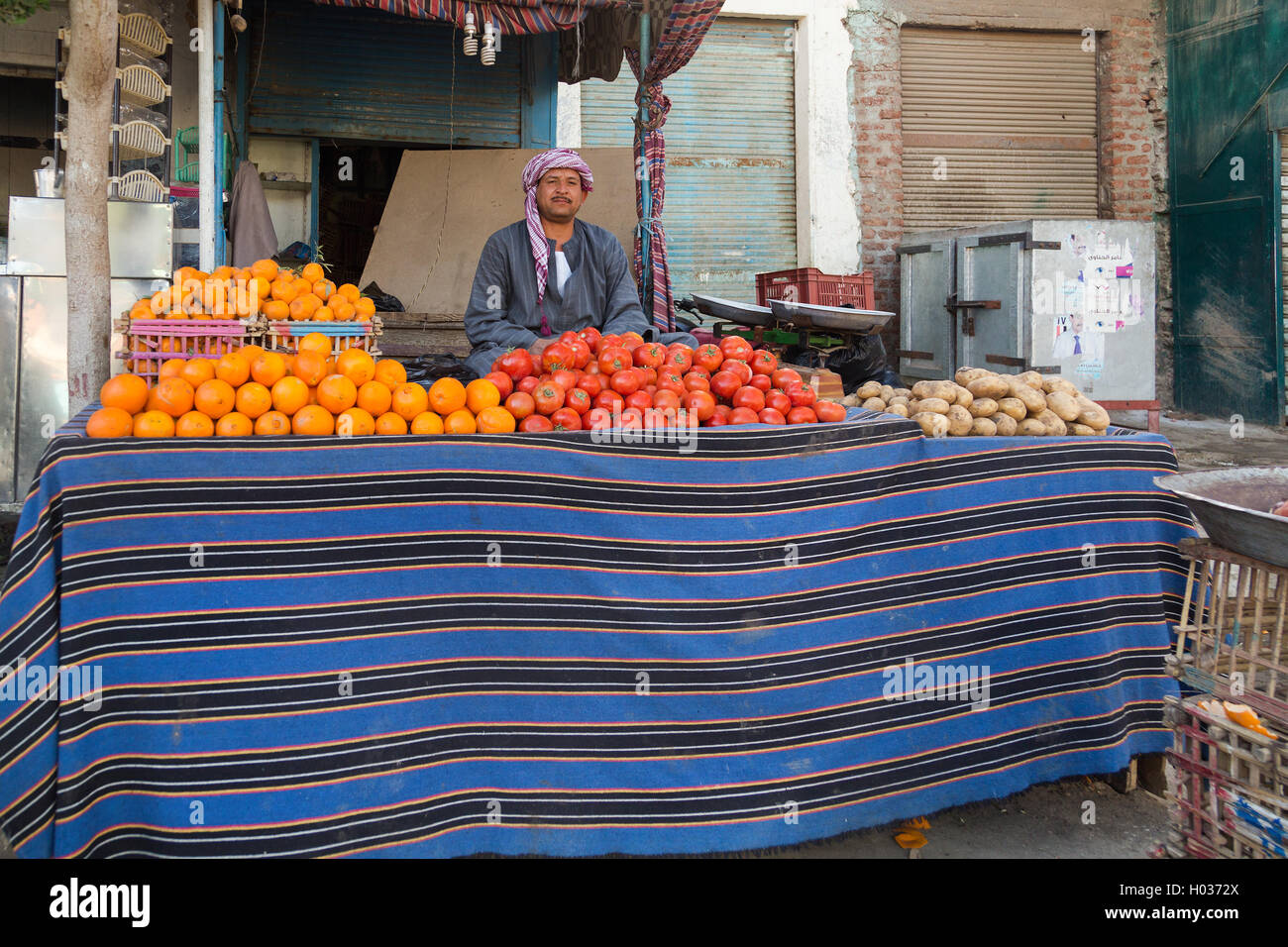 DARAW, EGYPT - FEBRUARY 6, 2016: Local food vendor at Daraw market selling oranges and tomatoes. Stock Photo