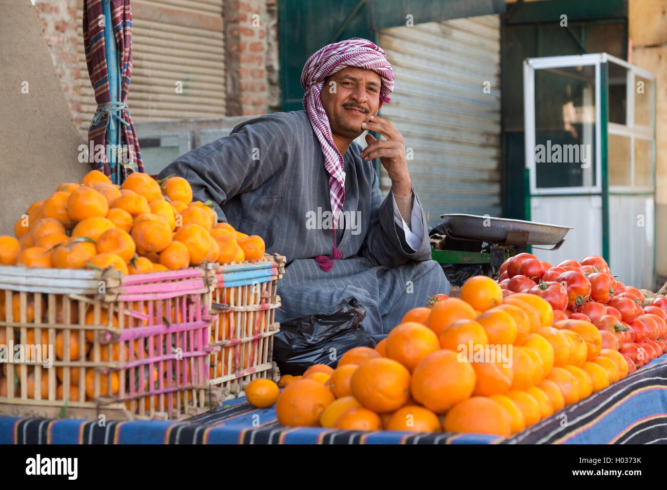 DARAW, EGYPT - FEBRUARY 6, 2016: Local food vendor at Daraw market selling oranges and tomatoes. Stock Photo