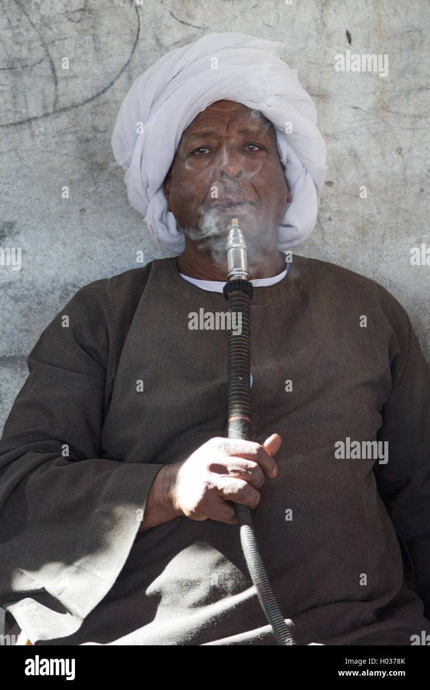 DARAW, EGYPT - FEBRUARY 6, 2016: Portrait of kocal camel salesman smoking shisha pipe. Stock Photo