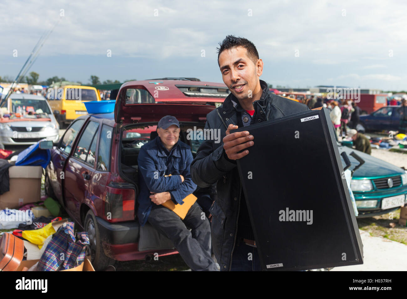 ZAGREB, CROATIA - OCTOBER 20, 2013: Roma salesman holding used speaker at Zagreb's flea market Hrelic. Stock Photo