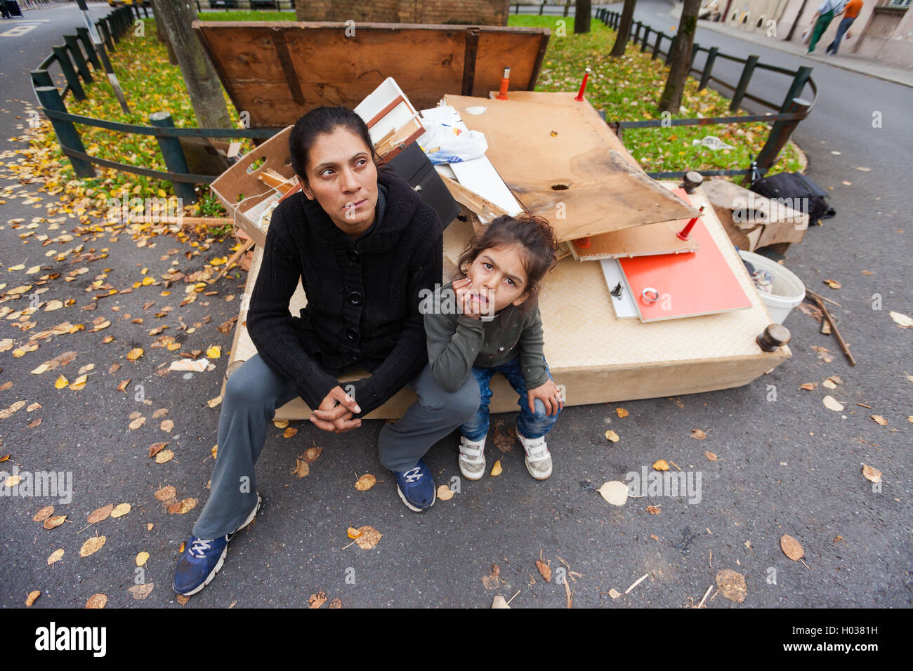 ZAGREB, CROATIA - OCTOBER 14, 2013: Roma mother and daughter sitting at the garbage dump. Stock Photo