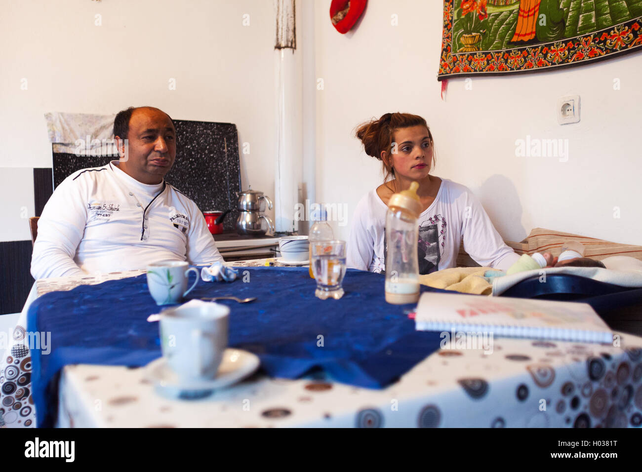 ZAGREB, CROATIA - NOVEMBER 12, 2013: Roma family sitting at kitchen table at their home. Stock Photo