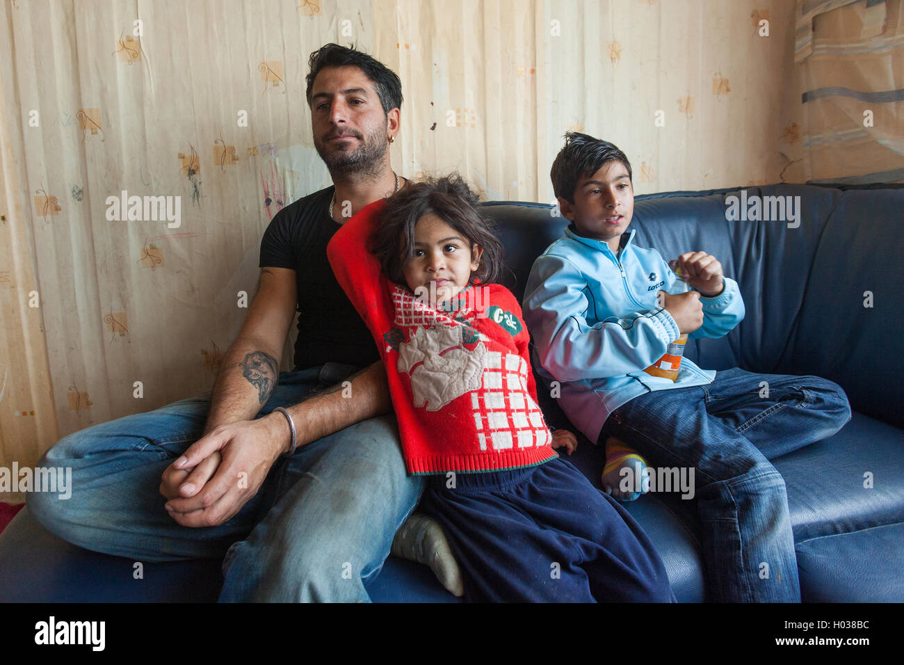 ZAGREB, CROATIA - OCTOBER 21, 2013: Roma man and his children at their home. Stock Photo