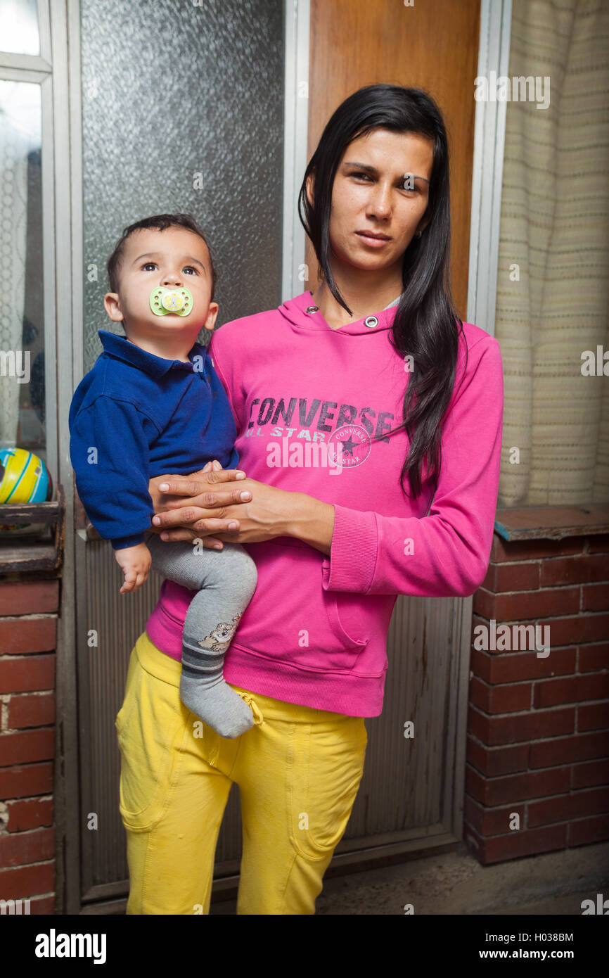 ZAGREB, CROATIA - OCTOBER 21, 2013: Roma mother holding baby in front of their house. Stock Photo