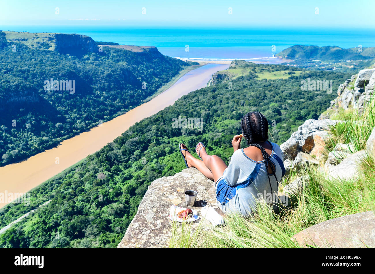 Girl having coffee with an aerial view of the the Umzimvubu river mouth in Port St Johns, Eastern Cape, South Africa Stock Photo