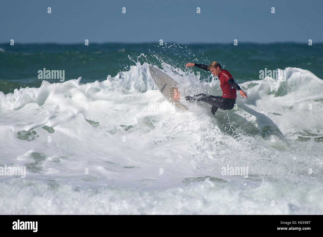 A competitor in spectacular surfing action at the Surfing GB Inter-Clubs Surfing Competition at Fistral in Newquay, Cornwall. UK. Stock Photo
