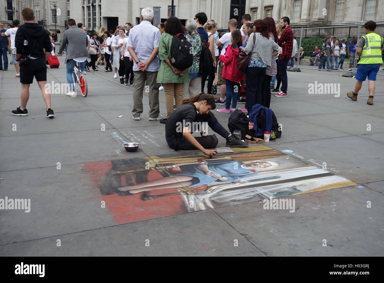 Street artist and picture of Queen Elizabeth II on pavement outside National Portrait Gallery, Trafalgar Square, London Stock Photo