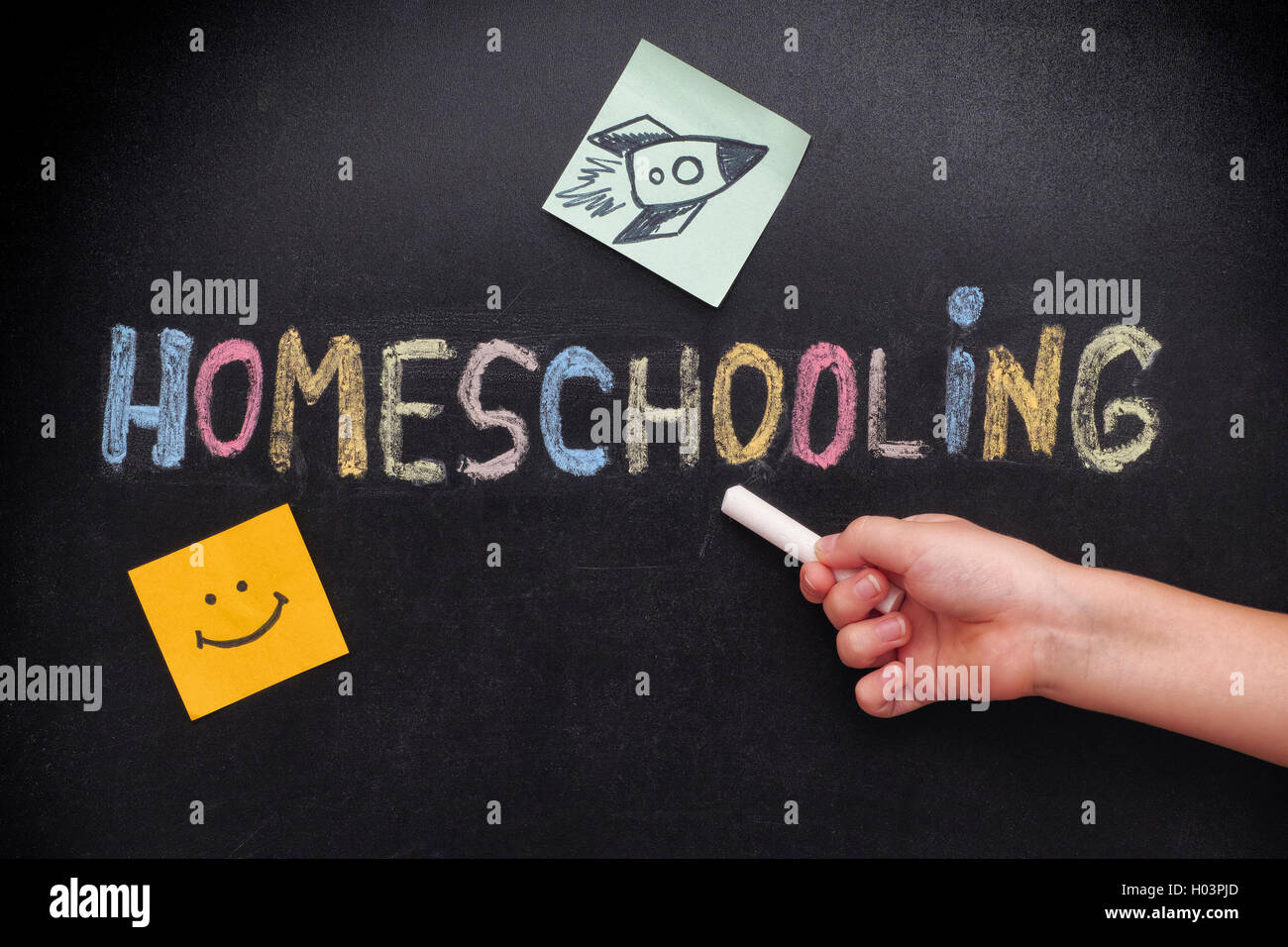 Homeschooling. Child pointing at word Homeschooling on a blackboard