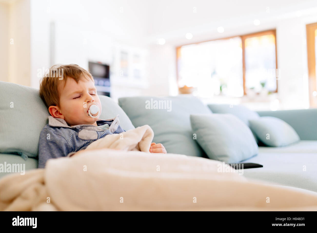 Sick child resting while wrapped in blanked Stock Photo