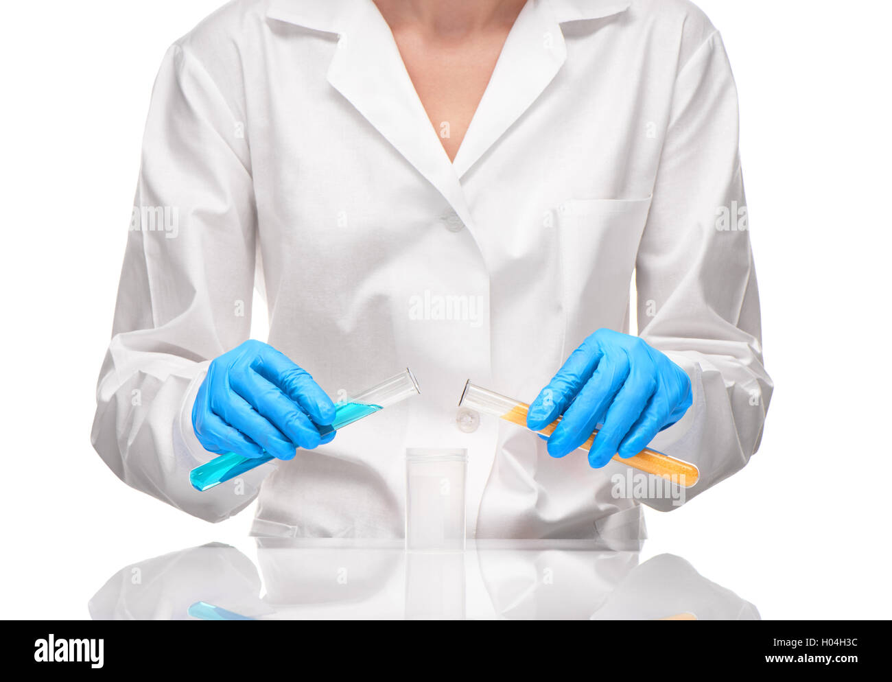Close up of female in white gown and blue gloves holding white glass test tubes and with yellow sorbent and blue liquid Stock Photo
