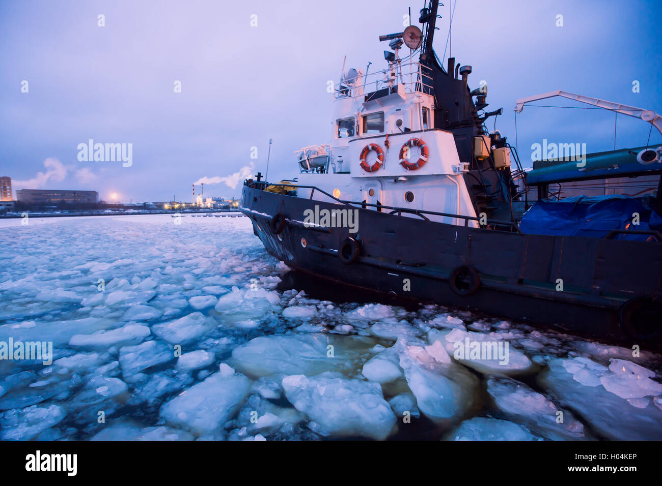The Icebreaker ship trapped in ice tries to break and leave the bay between the glaciers Stock Photo