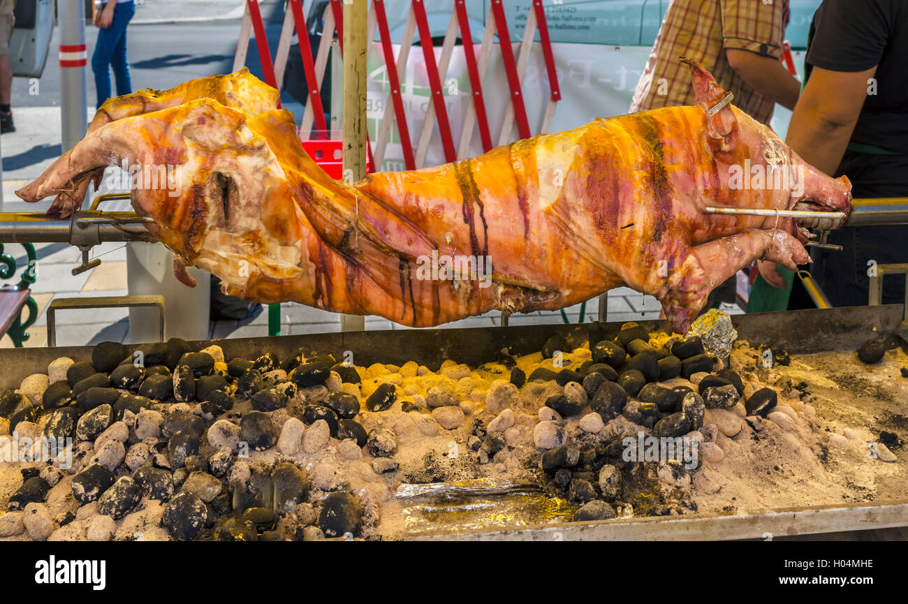 Whole pig roasting on a spit in the Naschmarkt, Linke Wienseile, Vienna, Austria Stock Photo
