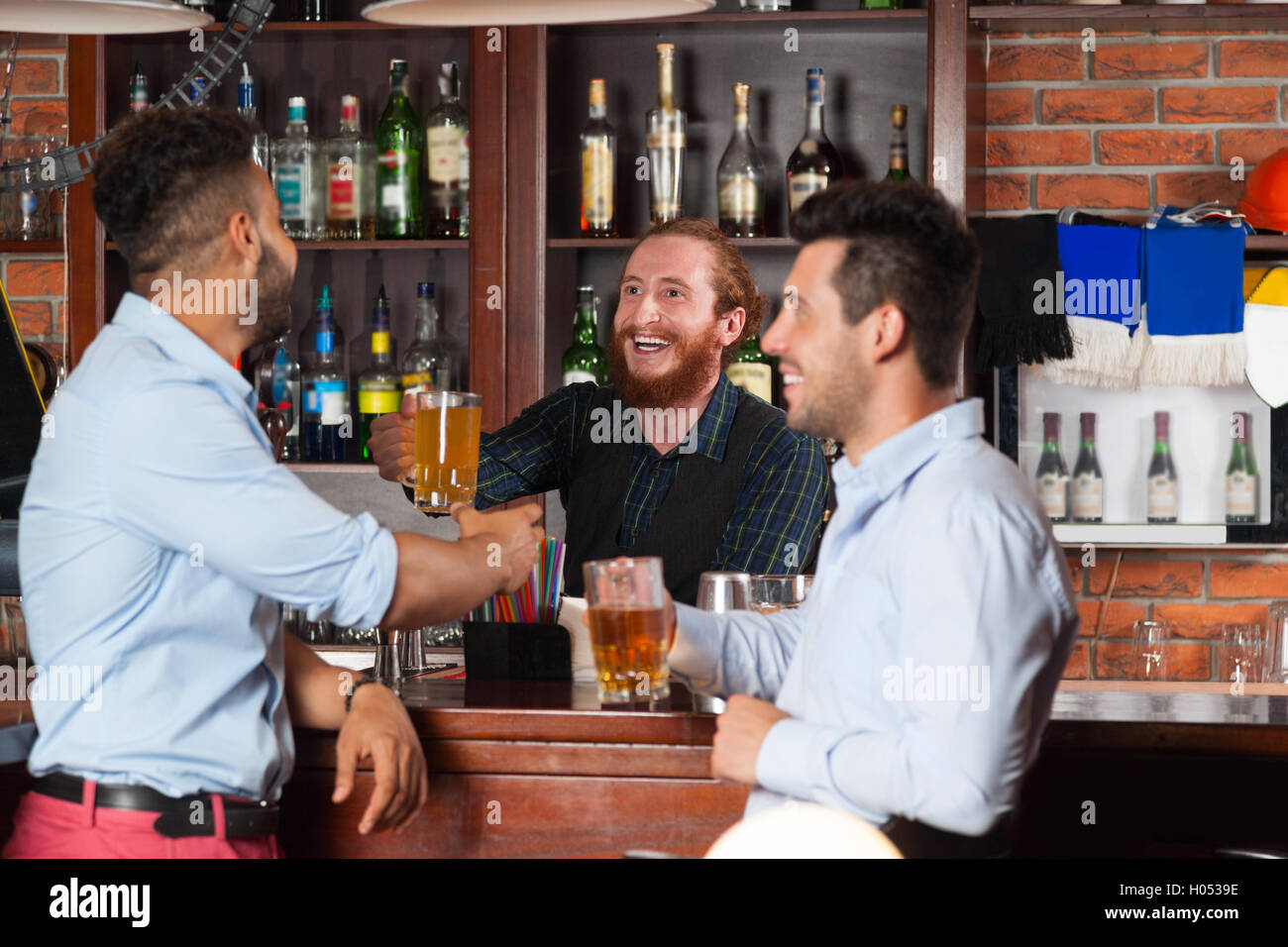 Two Man In Bar At Counter, Barman Giving Beer Glass, Friends Meeting Guys Cheerful Smiling Stock Photo