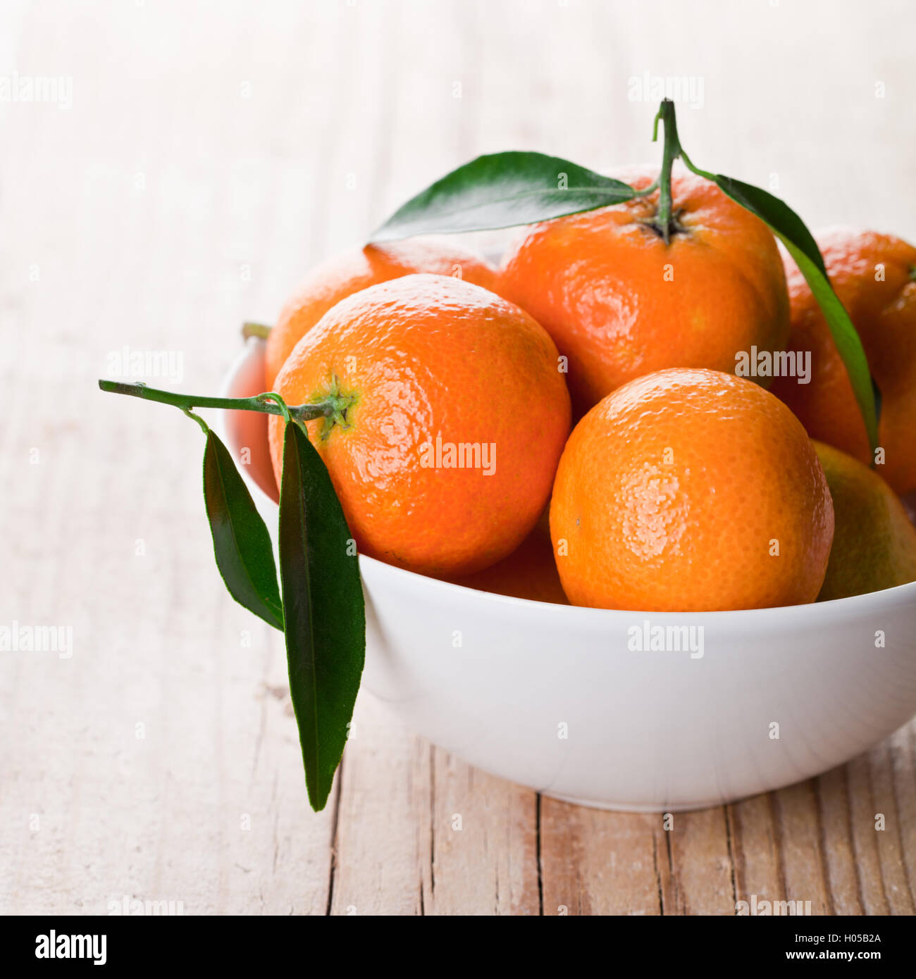 tangerines with leaves in bowl Stock Photo