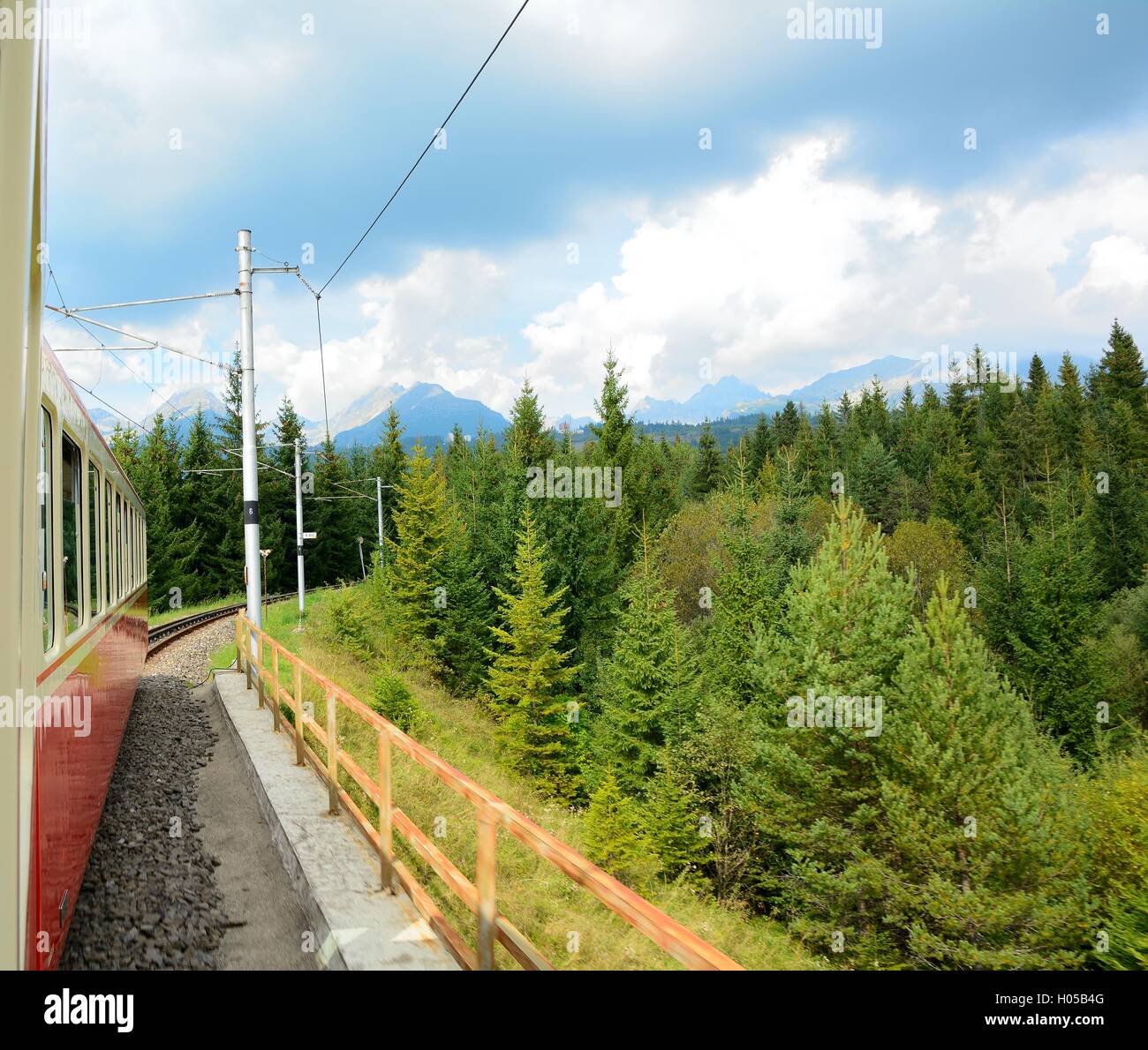 View of High Tatras mountains from window of speeding train on cog railway during way from Strba station to Strbske Pleso statio Stock Photo