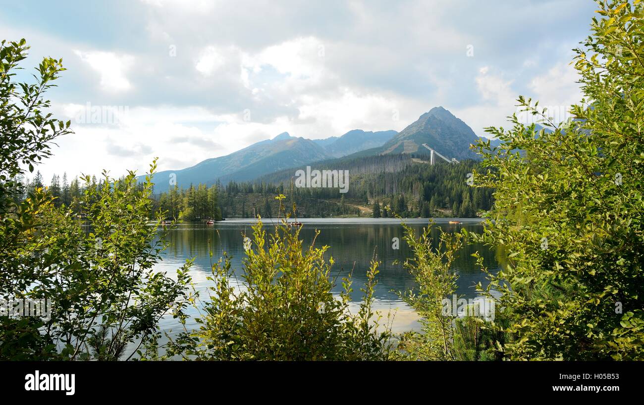 View of High Tatras mountains with ski jump from Strbske Pleso lake. Stock Photo