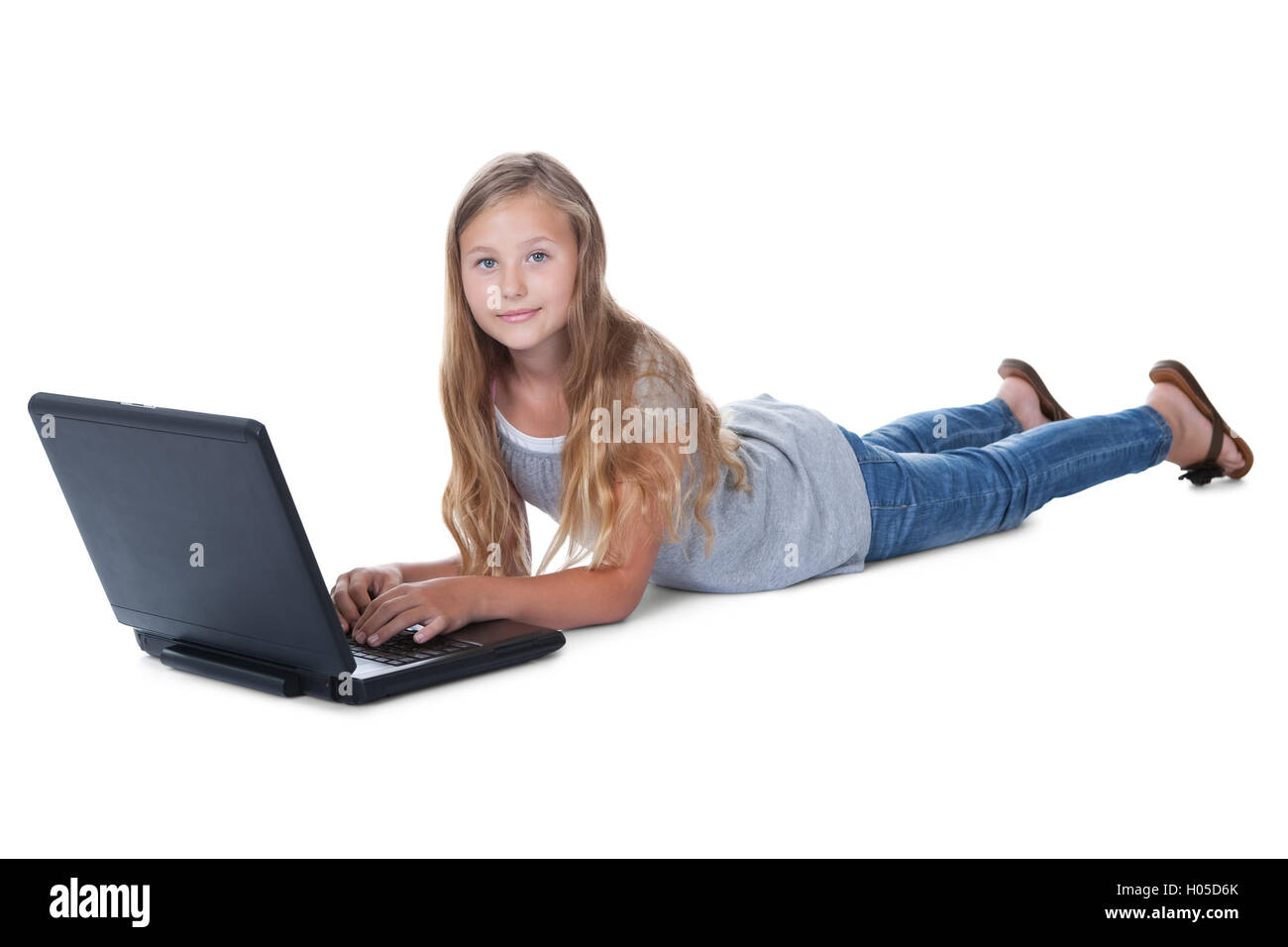 Little Girl Lying On Floor Using A Laptop Stock Photo - Alamy