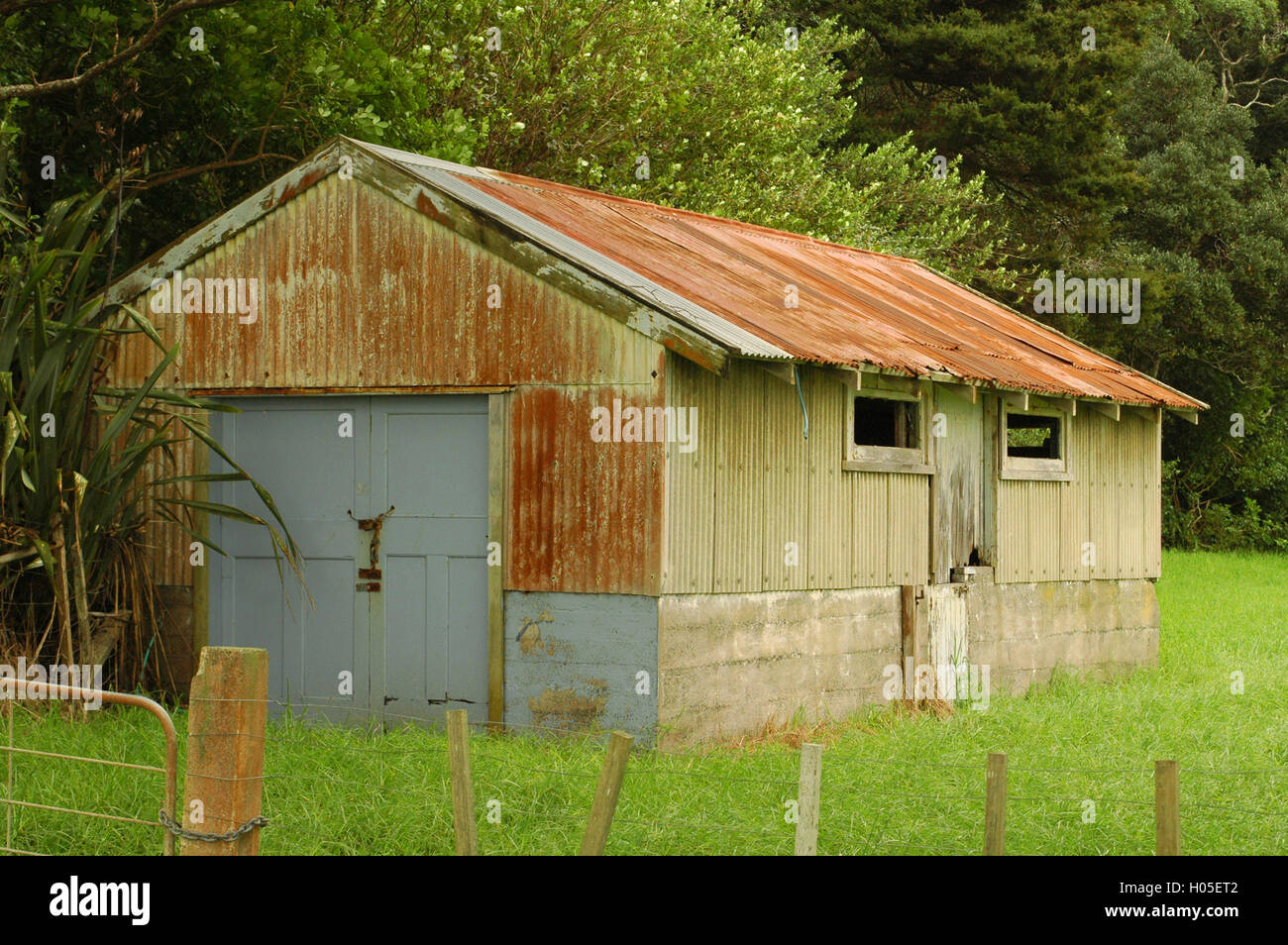 Shed made of rusty corrugated sheet metal on concrete base Stock Photo