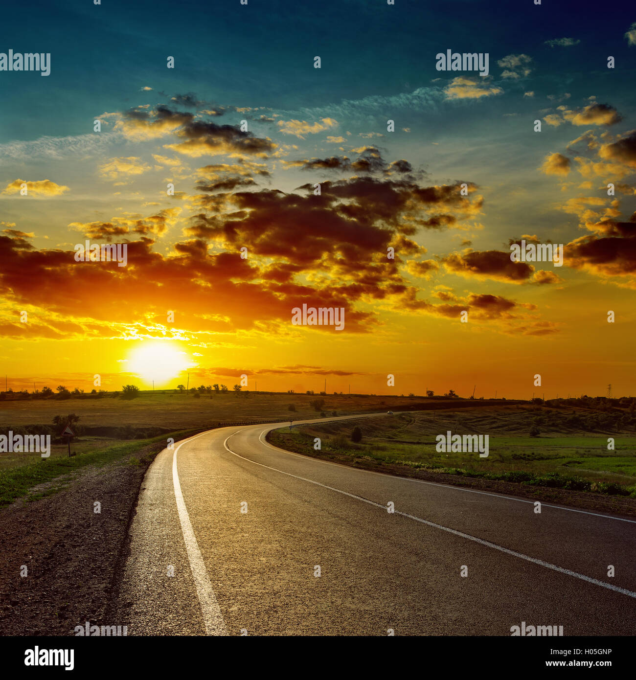 low orange sun over asphalt road Stock Photo - Alamy