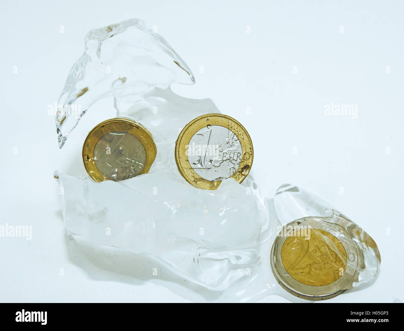 Cache euro coins in ice Stock Photo - Alamy