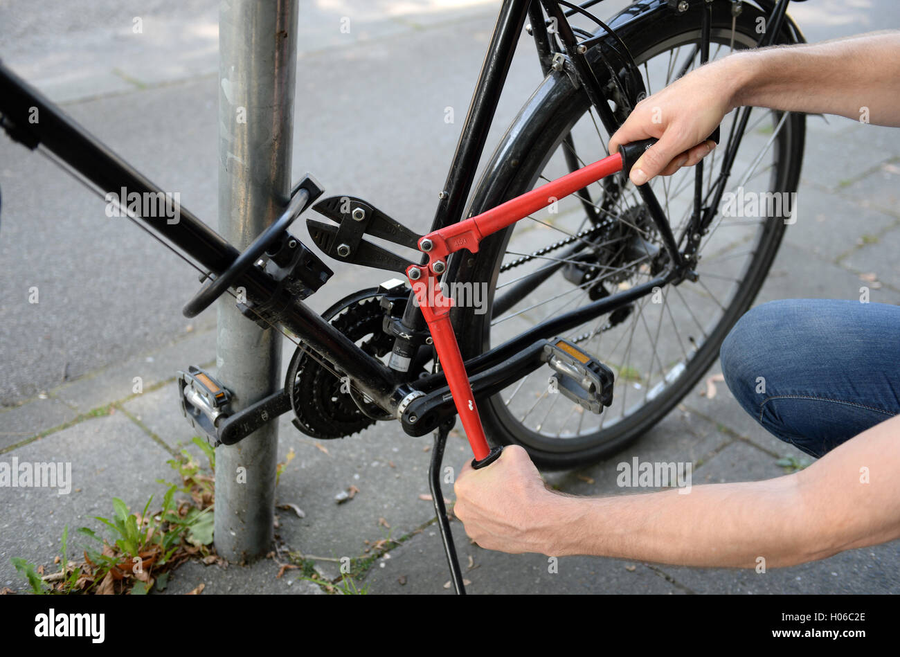 ILLUSTRATION - A man attempts to cut through a bike lock with bolt cutters  in Munich, Germany, 14 September 2016 (staged scene). PHOTO: ANDREAS  GEBERT/DPA Stock Photo - Alamy