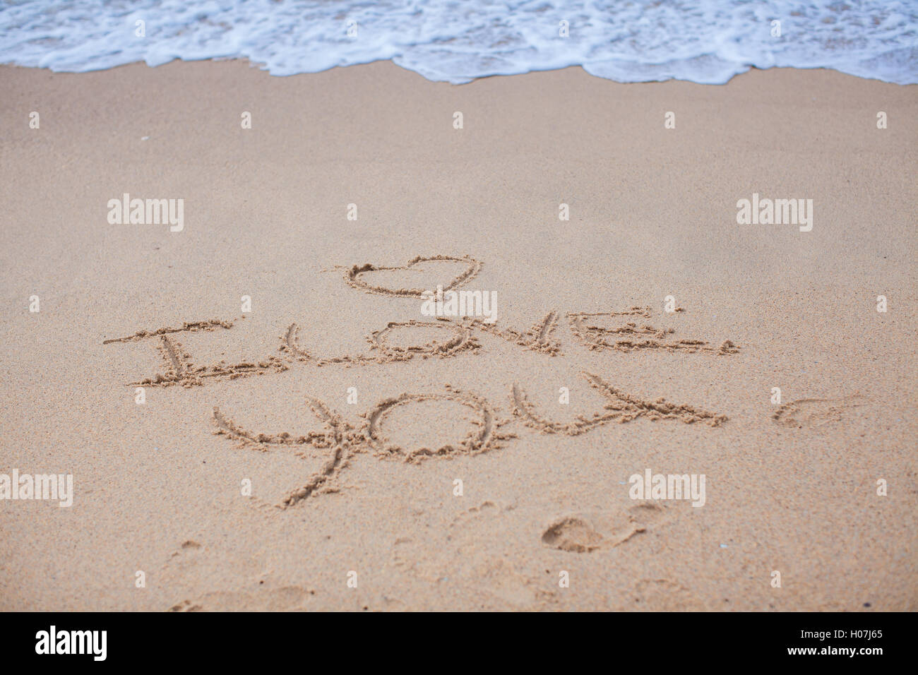 I love you on the sand near sea and waves Stock Photo