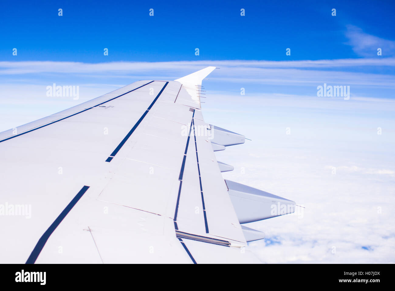Wing of an airplane flying above the clouds Stock Photo - Alamy