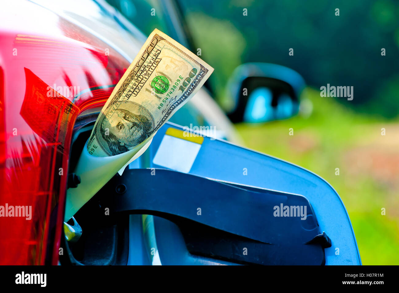 dollar bills sticking out of gas tank of a modern car Stock Photo Alamy