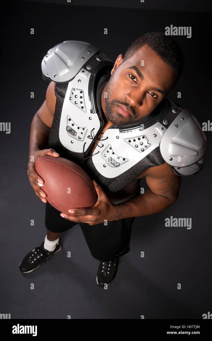 African American Man Football Player Shoulder Pads Looking Up Stock