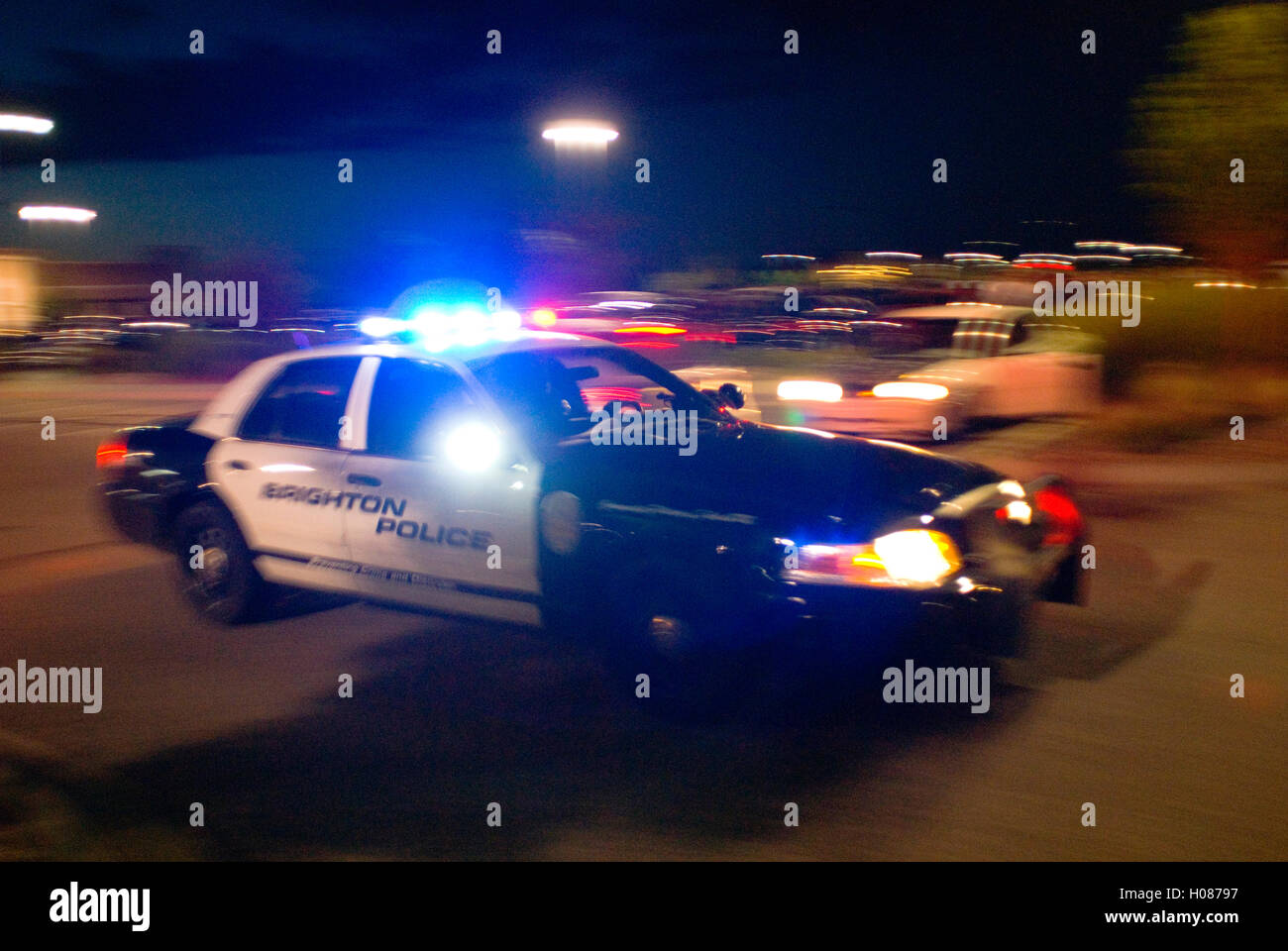 Police car speeds by at night with lights and siren on Stock Photo