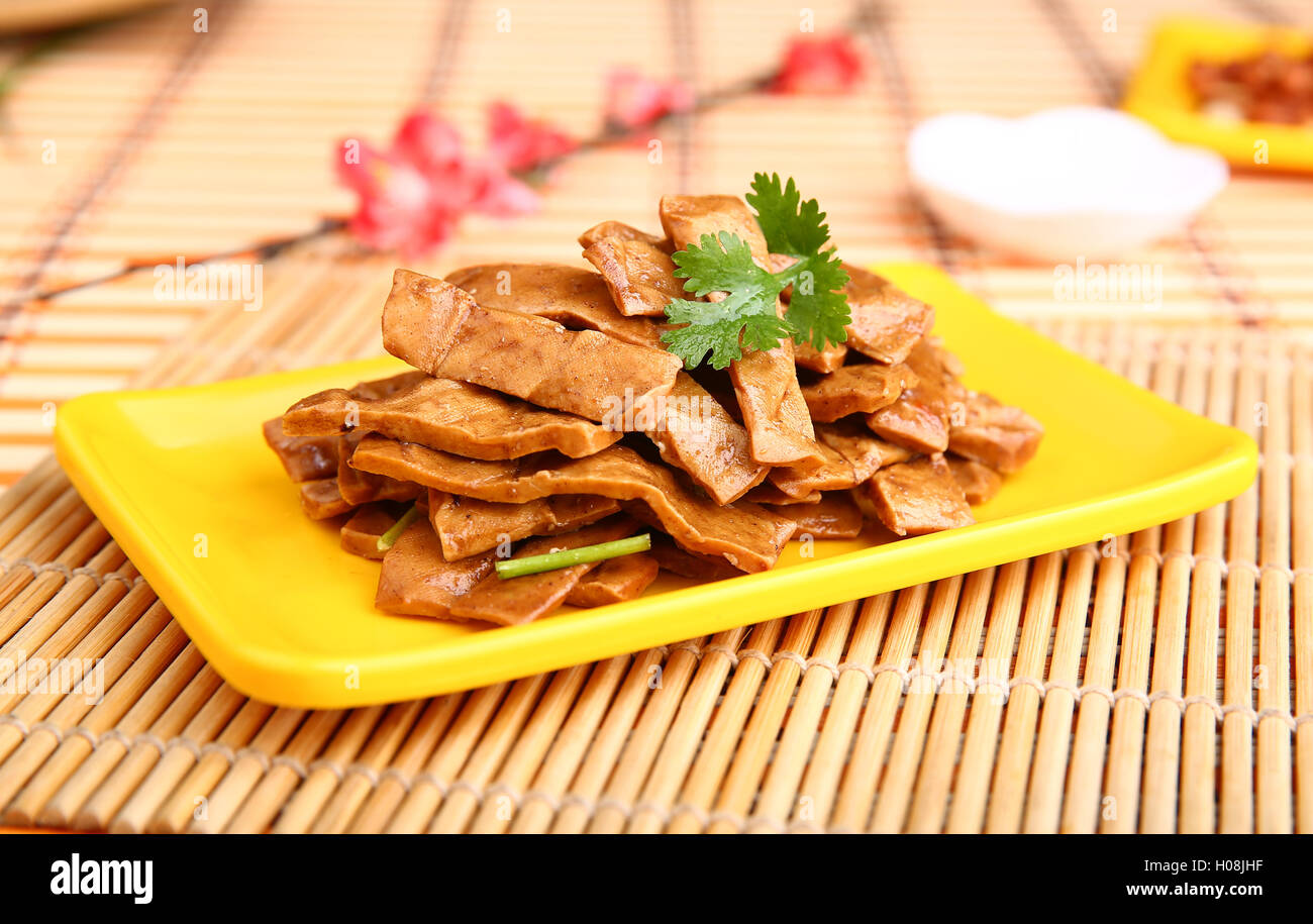 Fried sliced duck meat on yellow plate on the table in restaurant Stock