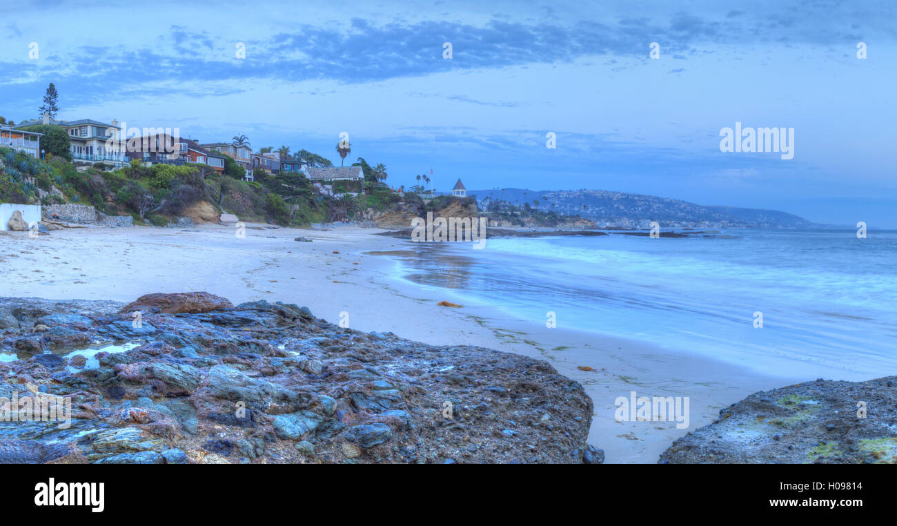 Sunset over the rocks at Shaws Cove in Laguna Beach as water flows over the stone in HDR Stock Photo