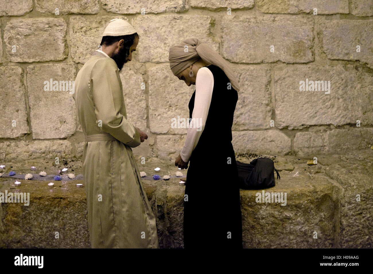 An ultra orthodox Jewish couple lighting candles at the entrance to King David tomb in mount Zion East Jerusalem Israel Stock Photo