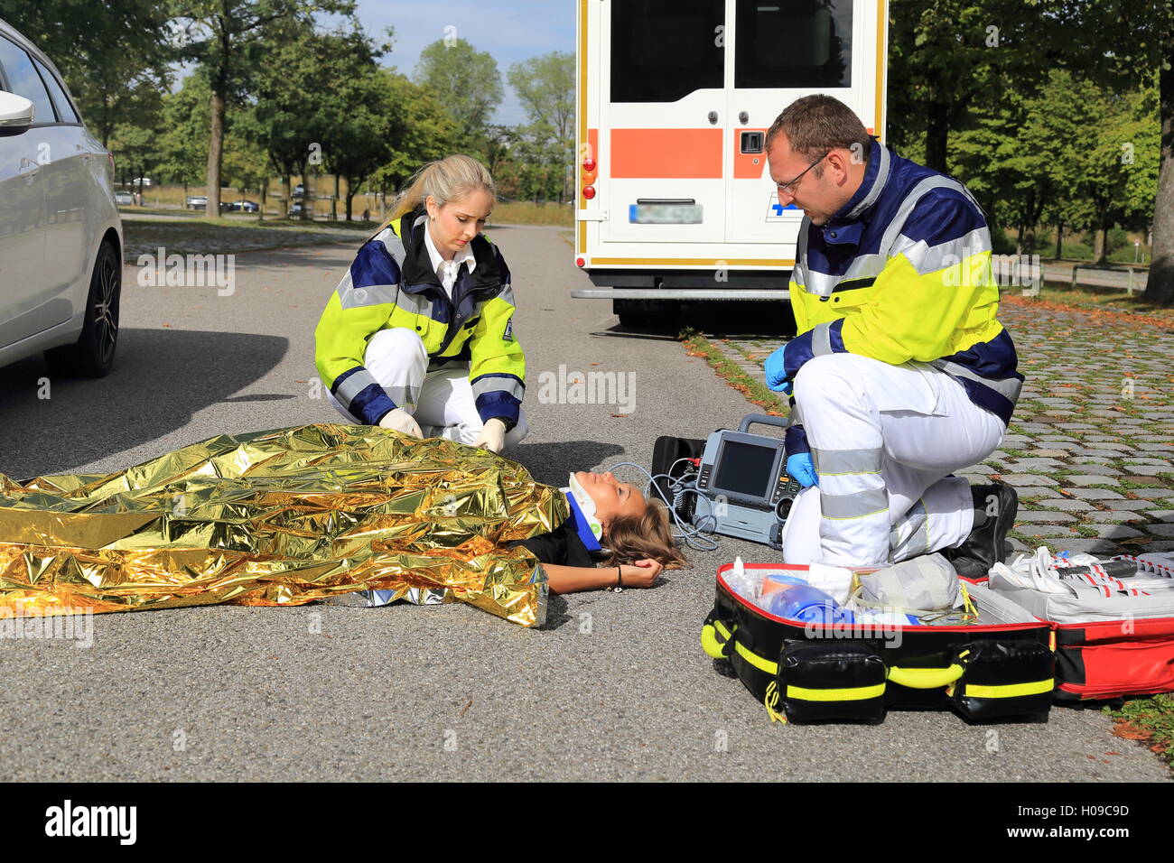 Two paramedics helping a woman after a traffic accident Stock Photo
