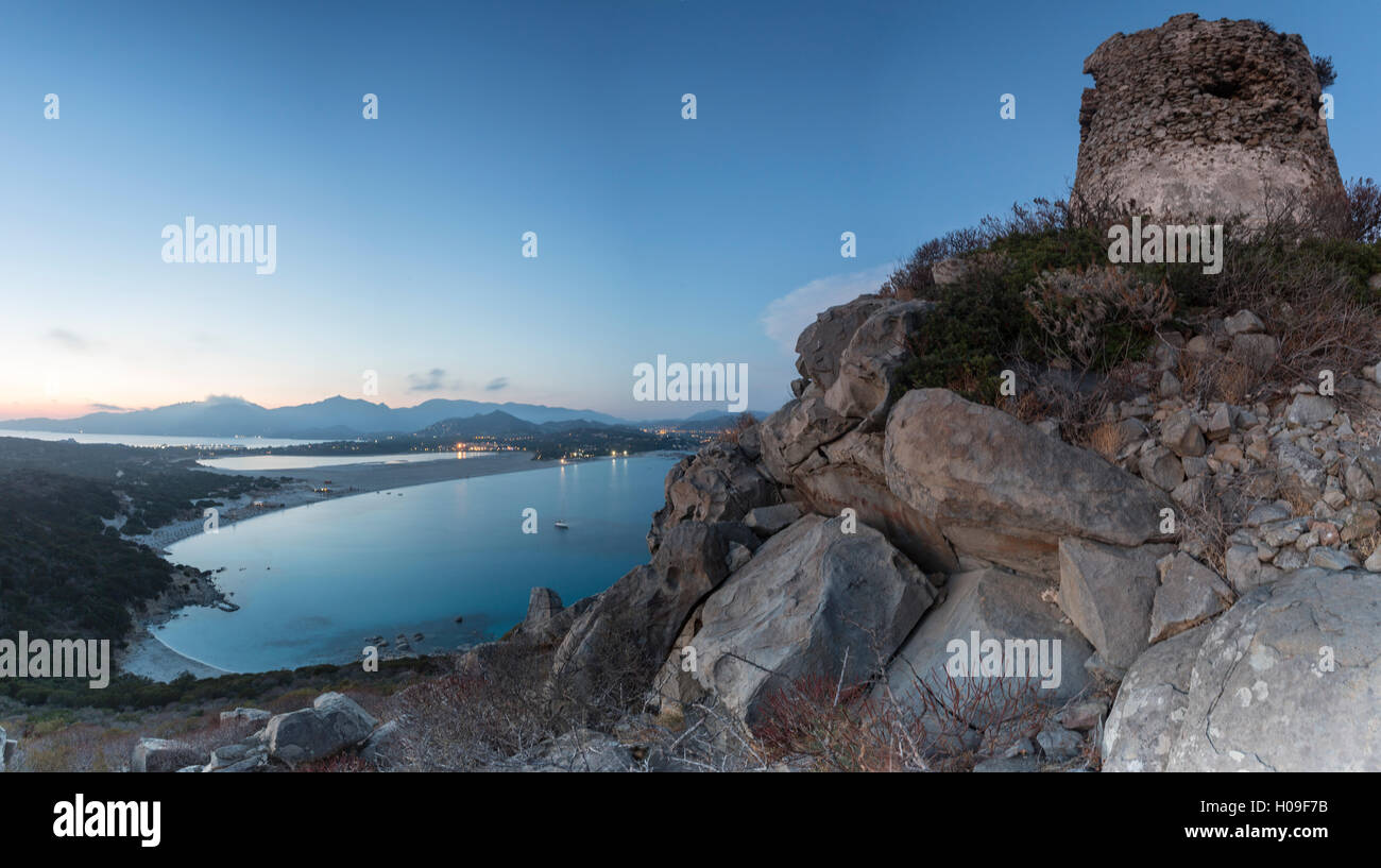 Top view of the bay with sandy beaches and lights of a village at dusk, Porto Giunco, Villasimius, Cagliari, Sardinia, Italy Stock Photo