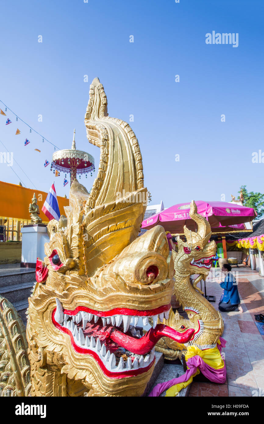 Naga head staircase and devotee at Doi Kham (Wat Phra That Doi Kham) (Temple of the Golden Mountain), Chiang Mai, Thailand Stock Photo