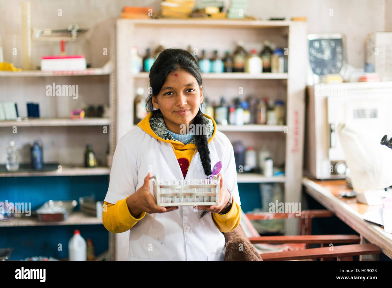 A young lab technician in a hospital in Nepal holds a rack of test tubes, Diktel, Khotang District, Nepal, Asia Stock Photo
