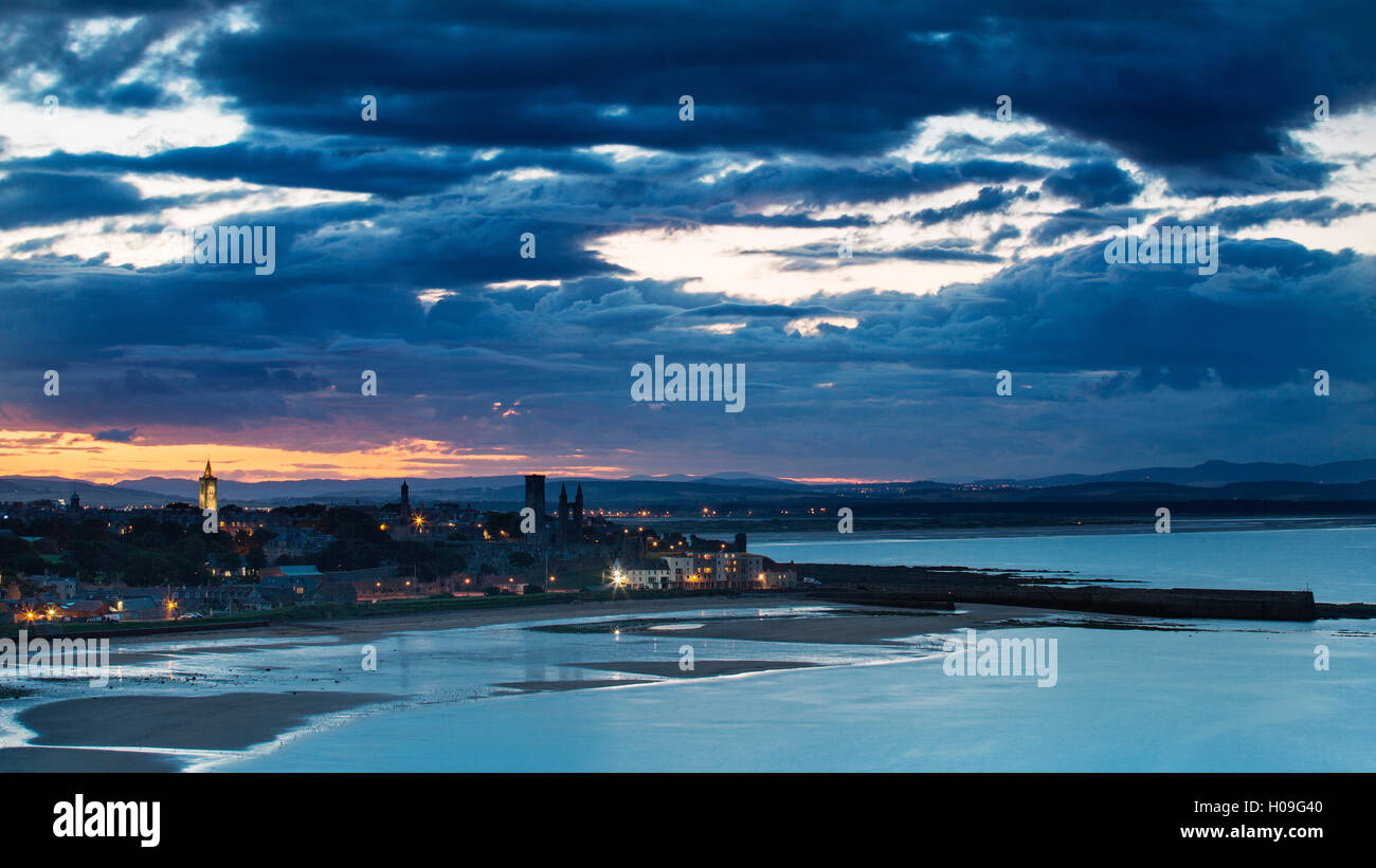 Looking across the bay to St. Andrews harbour and pier with the sun setting beyond the city, St. Andrews, Fife, Scotland, UK Stock Photo