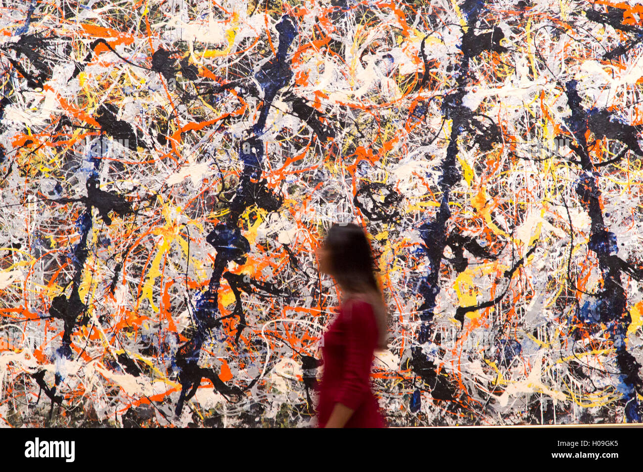 A woman walks past 'Blue Poles', 1952 by Jackson Pollock during a photocall at the Royal Academy of Arts, London. Stock Photo