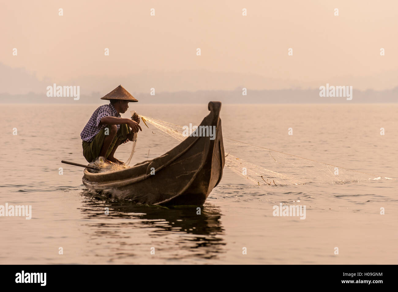 A fisherman pulls in his net on Indawgyi Lake in Kachin State, Myanmar (Burma), Asia Stock Photo