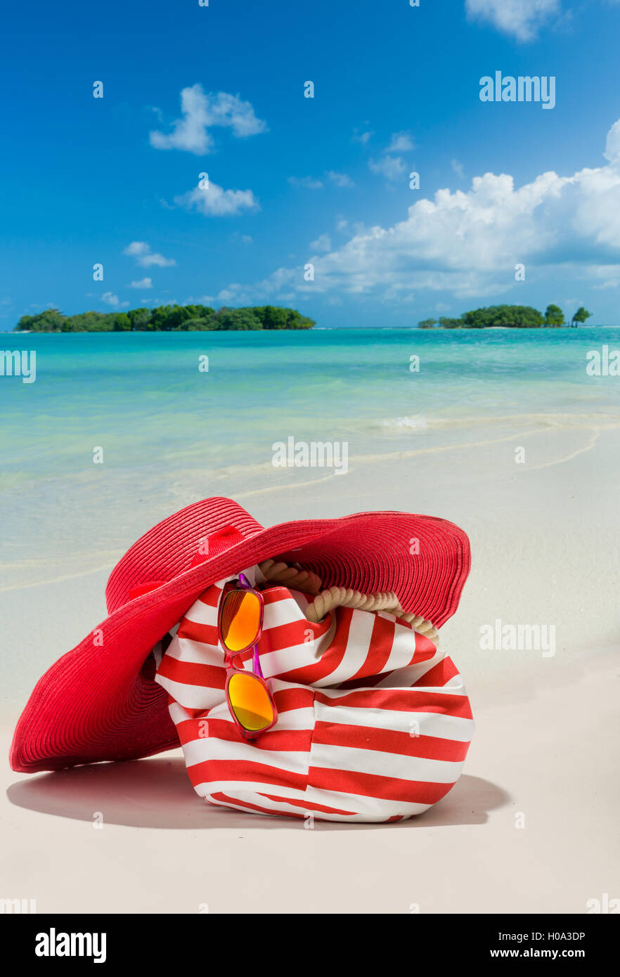 Summer beach bag with red straw hat and sunglasses on sandy beach Stock  Photo - Alamy