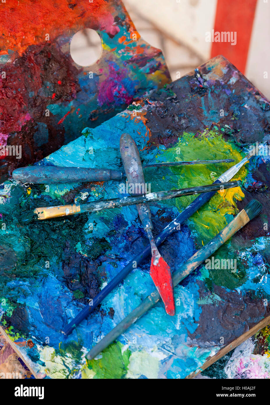 Artist paint palette brush knife and bright paint colour color Stock Photo