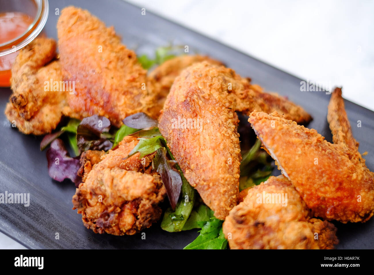 Fried chicken wings on black plate in restaurant Stock Photo Alamy
