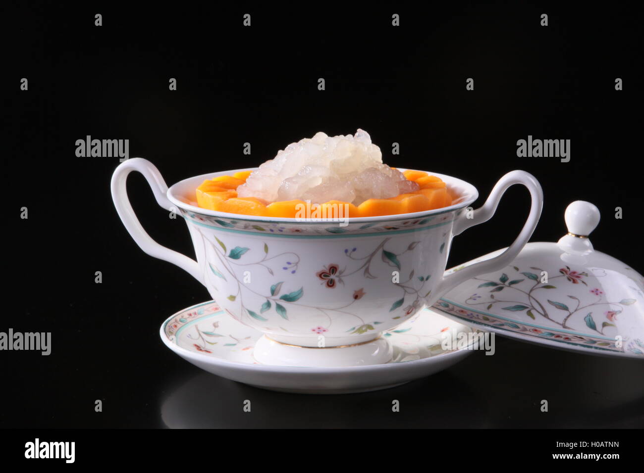 Mixed sweet fruit juice in chinese cup on black background Stock Photo